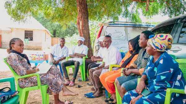 Community members seated together during a village meeting in rural Tanzania