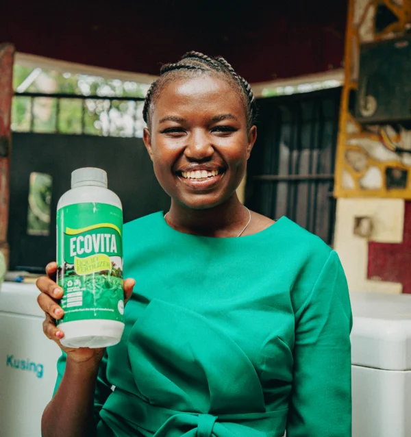 Woman in a green top smiling while holding a branded agricultural product